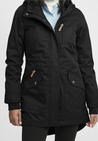 Svart långärmad jacka med dragkedja fram, huva, flera fickor och texturerad material med ett subtilt randigt mönster.