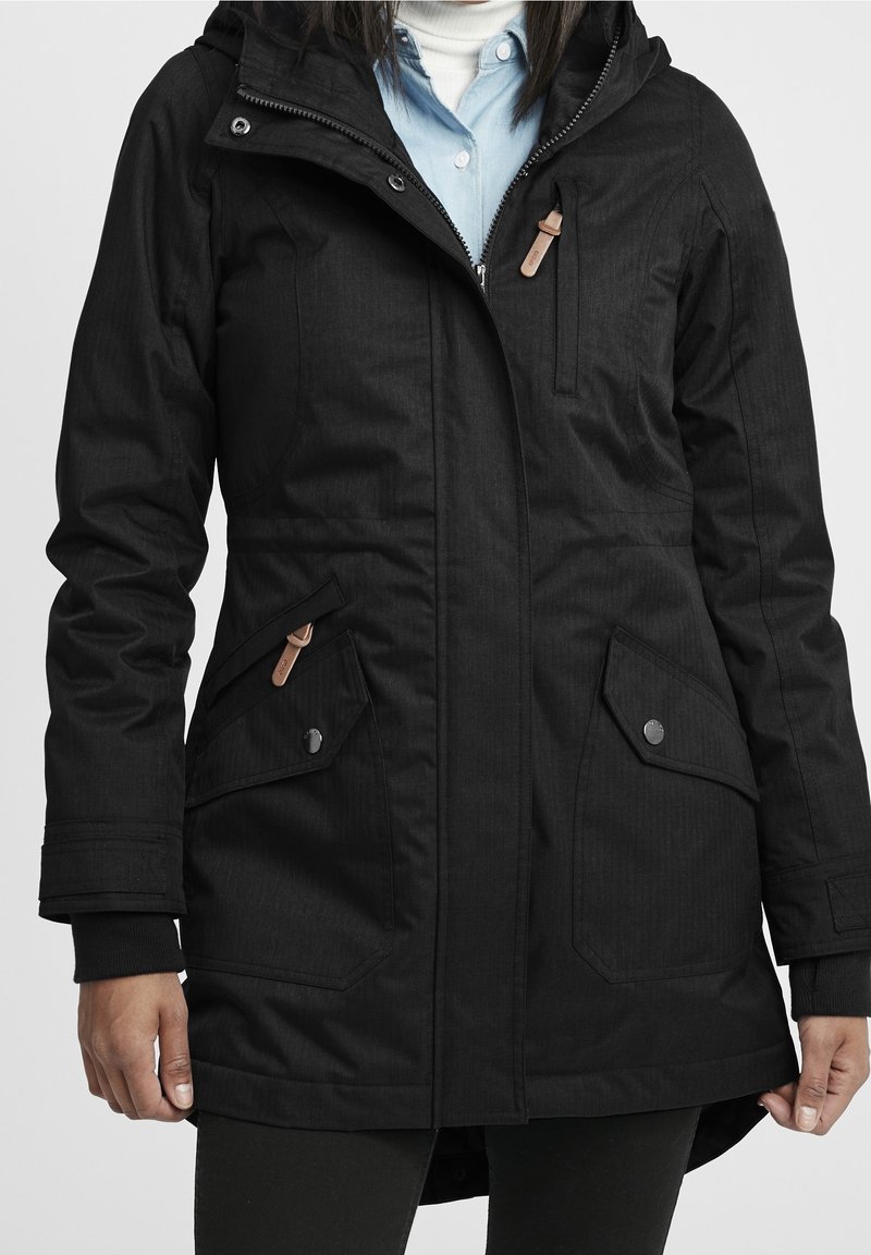 Svart långärmad jacka med dragkedja fram, huva, flera fickor och texturerad material med ett subtilt randigt mönster.