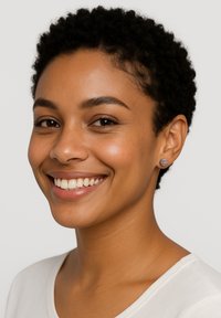 Små blå örhängen med geometriskt mönster, bärs av en modell med kort, lockigt hår och en ljusfärgad topp, som ler.