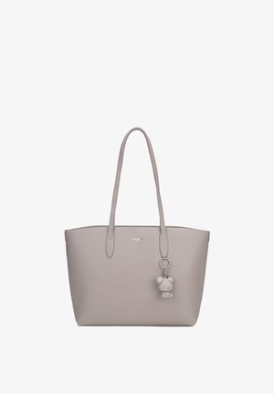 Sac cabas gris clair avec de longues anses et un porte-clés géométrique en forme d’ours suspendu à une anse, fond uni.