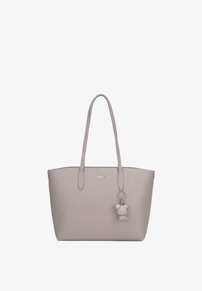 Sac cabas gris clair avec de longues anses et un porte-clés géométrique en forme d’ours suspendu à une anse, fond uni.
