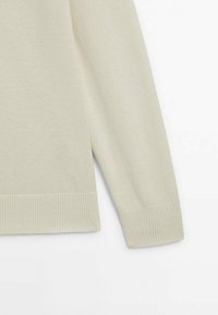 Pull beige à manches longues en maille avec poignets et ourlet côtelés, présenté sur fond blanc.