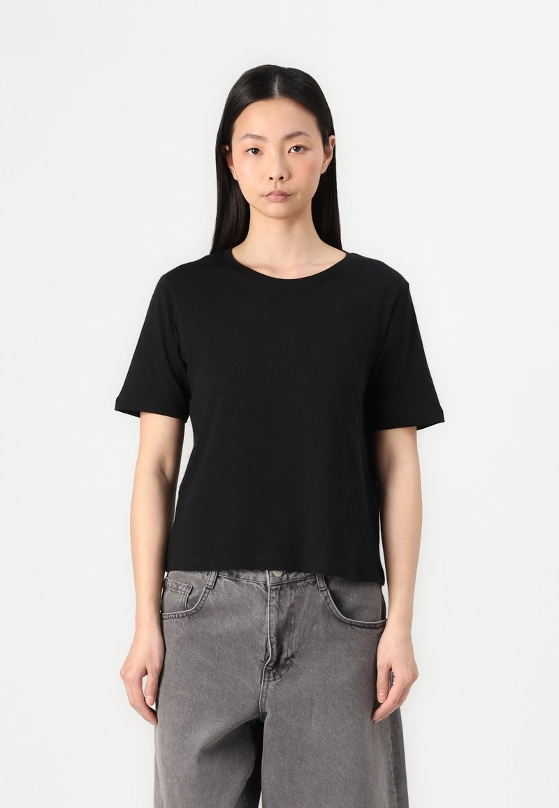 T-shirt noir à manches courtes avec un col rond, fabriqué en tissu doux, présentant une coupe décontractée et sans motifs ni accents visibles.