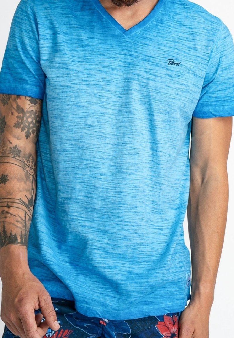 Ljusblå kortärmad V-ringad t-shirt med en melerad struktur, som har en liten logotyp på bröstet och detaljer i en liknande nyans.