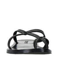 Zwarte platte sandalen met twee kruislings over elkaar lopende banden, vervaardigd uit glad leer met witte stiksels op de banden en de zool.