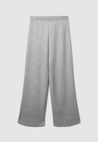 Pantaloni ampi grigi chiari con vita elasticizzata, realizzati in morbido tessuto a maglia, mostrati distesi su uno sfondo chiaro.