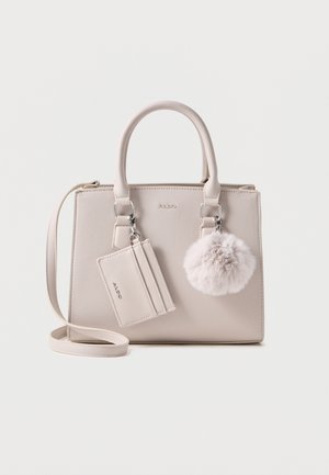 Borsa a mano sintetica beige con doppi manici, tracolla staccabile, dettaglio pom-pom in pelliccia e attacco per portacarte. Texture liscia.