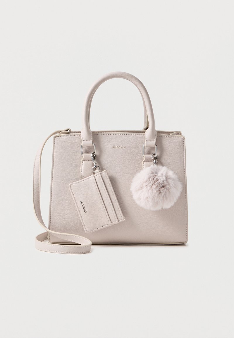 Beige synthetic handbag with dual handles, detachable shoulder strap, fur pom-pom accent, and cardholder attachment. Smooth texture.