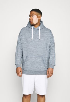 Sudadera gris texturizada con bolsillo canguro, cordones blancos y puños acanalados, combinada con pantalones cortos blancos. Diseño simple y casual.