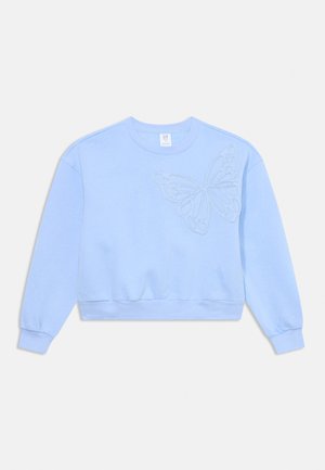 Sweatshirt bleu clair à col rond avec des manches longues et un motif de papillon texturé sur la poitrine gauche.
