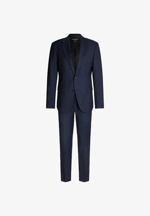 Costume bleu marine avec un blazer structuré et un pantalon droit. Confectionné dans un tissu texturé, il présente une fermeture à deux boutons et une fente à l'arrière.