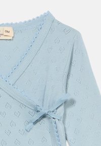 Jasnoniebieski kardigan o splocie dzianiny z ozdobnym falistym wykończeniem, wzorem w kształcie serc oraz wiązaniem w talii. Miękka faktura i długie rękawy.