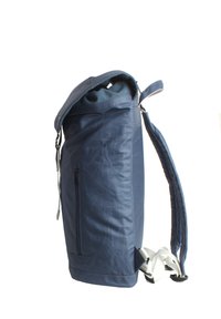 Sac à dos bleu marine avec un design à rabat, comportant une poche zippée sur le côté, des bretelles rembourrées et une texture lisse. Construction en tissu durable.