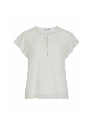 Hvit bluse med korte volang-ermer, rund hals og knytedetalj foran. Texturert stoff har små hevede prikker gjennom hele.