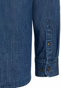 Denimskjorte med en mørkeblå nuance, som har en knaplukket manchet, struktureret stof og et subtilt vævet mønster gennem hele.