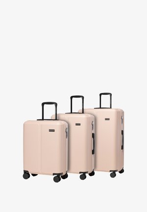 Drei weiche rosa Koffer mit vertikaler gerippter Textur, schwarzen Teleskopgriffen und vier Rädern für Mobilität, mit einem Markenemblem.