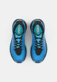 Blaue Sportschuhe mit einem Mesh-Obermaterial, schwarzen Akzenten und einer dicken Sohle. Verfügt über Schnürsenkel und ein prominent an der Seite angebrachtes Logo.