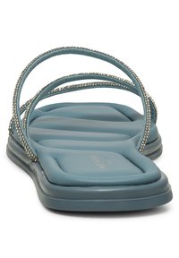 Blue slide sandals featuring a padded footbed, curved straps adorned with small rhinestones, and a smooth, textured upper.