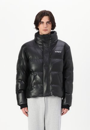 Black puffer jacket with a glossy finish, high collar, horizontal quilted pattern, front zip closure, and side pockets. Accented with white logo.