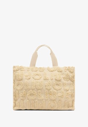 Beige tote bag with textured, fluffy fabric featuring raised lettering patterns. The bag has short, sturdy handles for easy carrying.