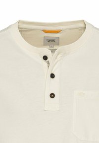 Kortebloemige crèmekleurige shirt, met een geribbelde kraag, drie zwarte knopen, een borstzakje aan de linkerzijde en een klein logoaccent.