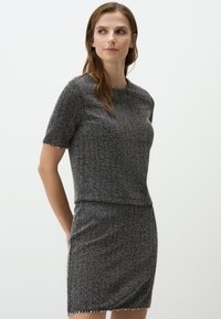 Robe grise en tissu texturé, à manches courtes, col rond et design ajusté, avec une bordure décorative à l'ourlet.