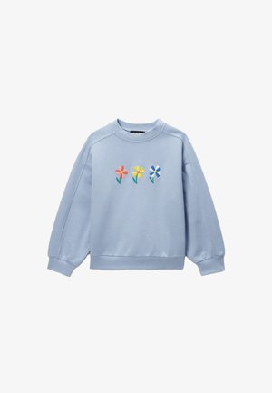 Sweatshirt bleu clair avec trois fleurs brodées en rose, jaune et bleu au centre de la poitrine, col rond, et bords-côtes aux poignets et à l'ourlet.