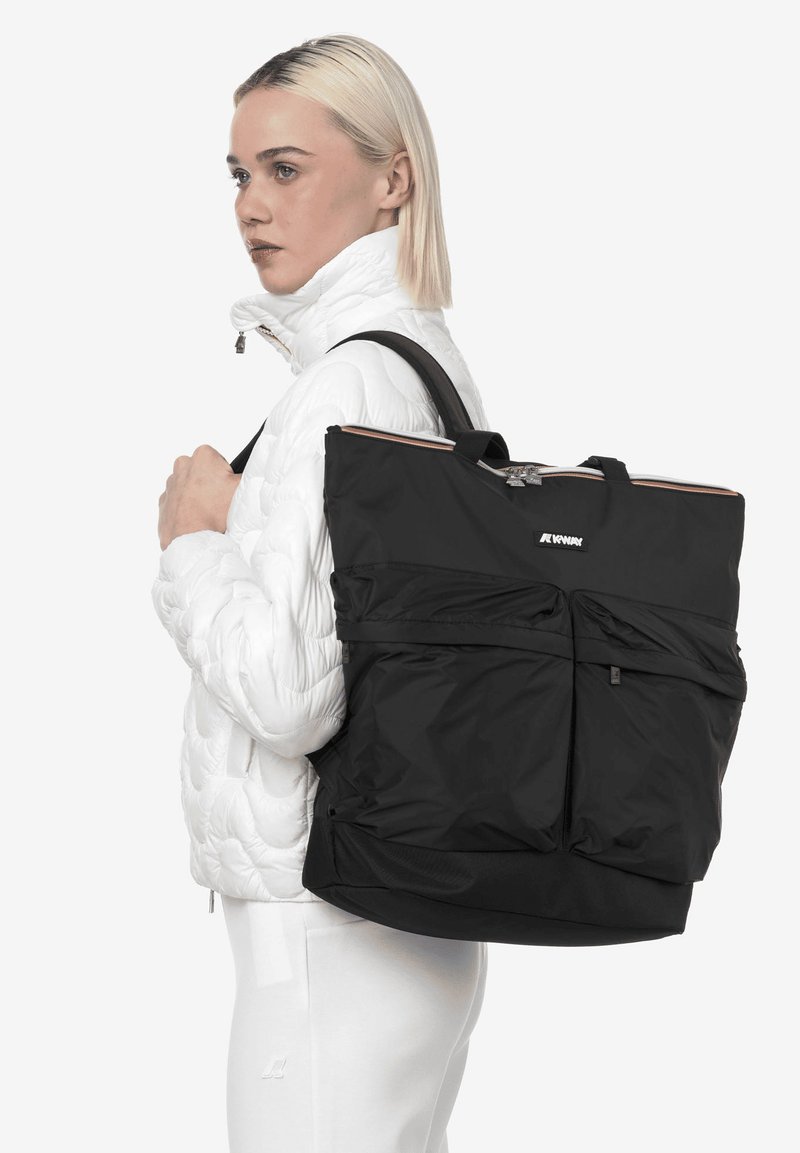 Sac fourre-tout en nylon noir avec deux poches avant, poignées supérieures et fermeture éclair. Texture lisse avec un design minimaliste.
