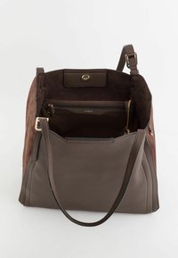 Sac à main en cuir et en daim marron avec un intérieur spacieux, des accessoires en or, une poche zippée et une bandoulière réglable.