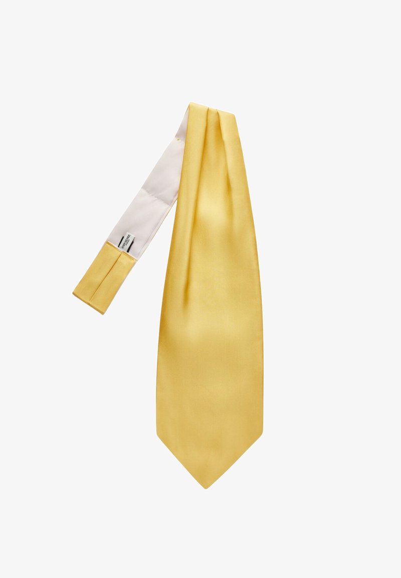 Keltainen satiininen solmio, jossa on sileä rakenne, kapea muoto ja terävä kärki. Alapuoli on valkoinen ja siinä on etiketti.