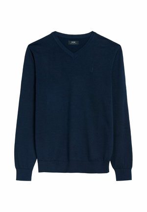 Granatowy sweter dzianinowy z dekoltem w kształcie litery V, długimi rękawami oraz ściągaczami przy mankietach i dole. Posiada małe, subtelne logo na klatce piersiowej. Wykonany z gładkiego materiału.