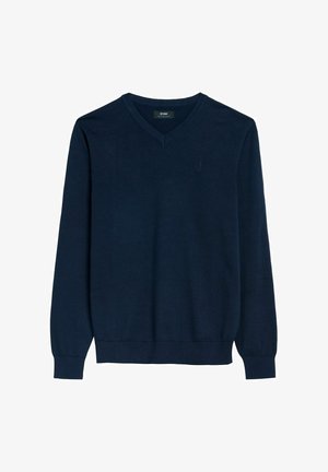 Granatowy sweter dzianinowy z dekoltem w kształcie litery V, długimi rękawami oraz ściągaczami przy mankietach i dole. Posiada małe, subtelne logo na klatce piersiowej. Wykonany z gładkiego materiału.