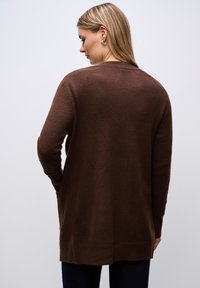 Brown knit cardigan featuring long sleeves, ribbed cuffs, and an open front design. Soft texture with a relaxed fit and side pockets.
