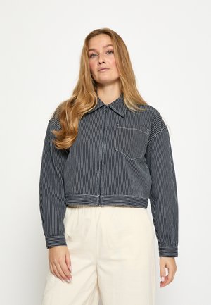 Croppede jakke i marineblå med hvide striber, med krave, lynlås foran og enkelt lomme. Stoffet har en tekstureret overflade.