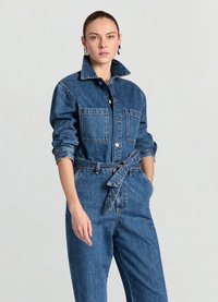 Jeans-Overall mit langen Ärmeln, durchgehend geknöpftem Vorderteil und zwei Brusttaschen. Verfügt über einen taillierten Gürtelbund und klassisch blaue, leicht strukturierte Stoffqualität.