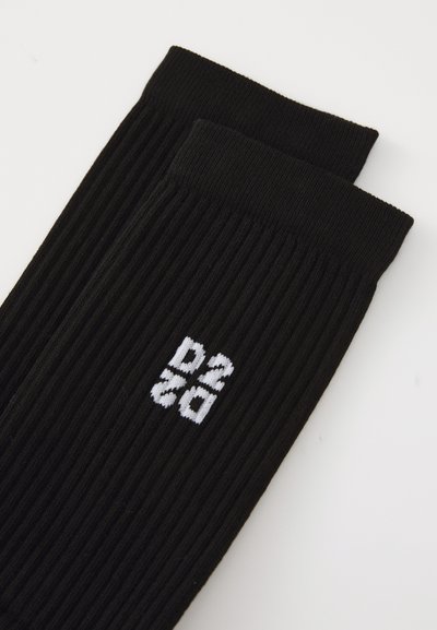 Fekete bordázott zoknik oldalukon egy kötött fehér "D2" logo-val. Az anyag lágynek tűnik, texturált felülettel.