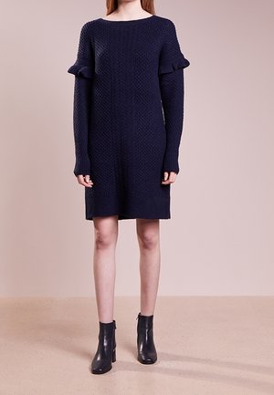 Abito lavorato a maglia blu navy con vestibilità ampia, caratterizzato da maniche lunghe e dettagli arricciati sui polsini. Tessuto morbido con scollatura rotonda.