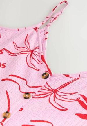 Rosa tygklänning med en texturerad yta, prydd med röda blommönster och fyra bruna knappar längs knäppningen, justerbara axelband.