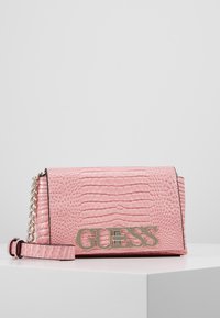 Rosa faux læder crossbody taske med krokodilletekstur, metallisk guld "GUESS" logo, kædestrop og en struktureret rektangulær form.