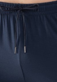 Mörkblå sportshorts med elastisk midja, utrustade med snöre med metallaglar och slätt, stretchigt tyg.