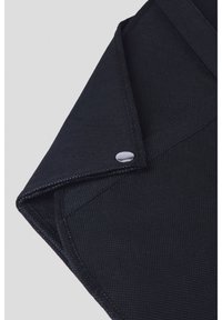 Czarna teczka z tkaniny o teksturowej powierzchni, z klapą zapinaną na okrągły metalowy zatrzask.