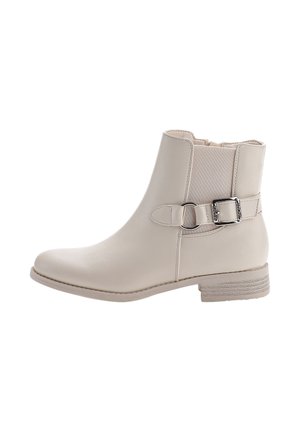 Bota de tobillo de cuero beige con un acabado suave, punta redondeada, panel elástico lateral y una hebilla decorativa en el tobillo. Tacón plano y texturizado.