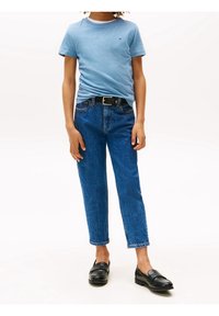 Jasnoniebieska bawełniana koszulka z krótkim rękawem, zestawiona z spodniami dżinsowymi o wysokim stanem i prostych nogawkach w ciemnoniebieskim kolorze oraz czarnymi mokasynami. Pasuje czarny pasek.