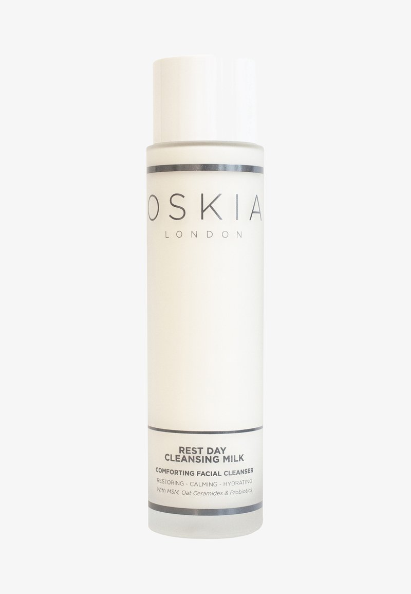 Weiße Flasche mit matter Oberfläche, schwarzem Text und zylindrischer Form. Das Etikett lautet "REST DAY CLEANSING MILK" mit Produktdetails darunter.