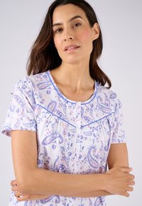 Camicia da notte a maniche corte in tessuto leggero con stampa floreale paisley nei toni del rosa e blu. Caratterizzata da un collo rotondo e una chiusura con bottoni.