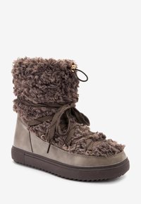 Bota alta de felpa en marrón oscuro con parte superior texturizada, diseño con cordones y suela de goma que presenta un patrón de tread plano.