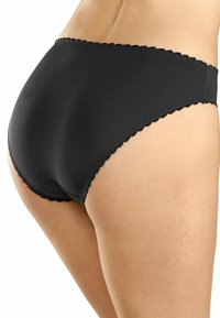 Mutande nere con un taglio alto in vita. Texture liscia, bordi ondulati e cuciture minime per comfort e un aspetto senza soluzione di continuità.