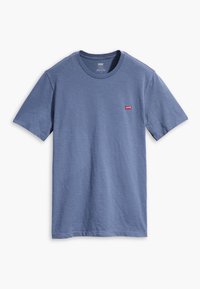 Tričko s krátkým rukávem a kulatým výstřihem z světle modré látky, s červenou visačkou Levi's na levé části hrudi. Měkká textura, volný střih.