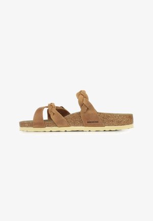 Sandali beige in suede con cinturini intrecciati, soletta in sughero e suola in gomma chiara. Presentano un logo di marca sul lato.