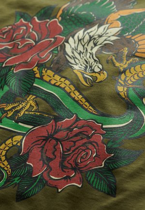 Olijfgroene stof met een gedurfde grafische print van rode rozen, een witte adelaar en een slang in gele en groene tinten, waarbij de ingewikkelde details worden benadrukt.